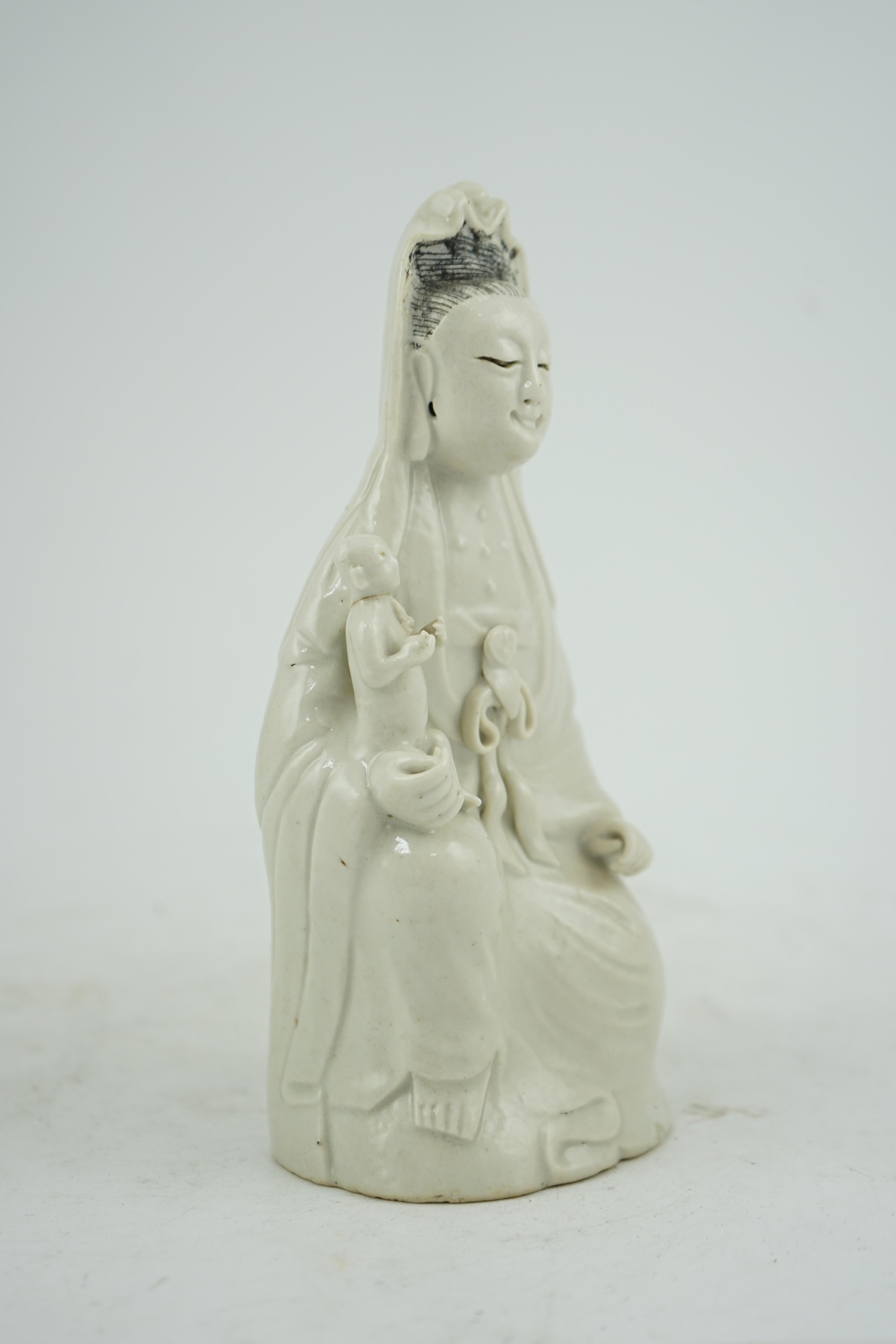 A Chinese white glazed group of Guanyin and child, 18th/19th century